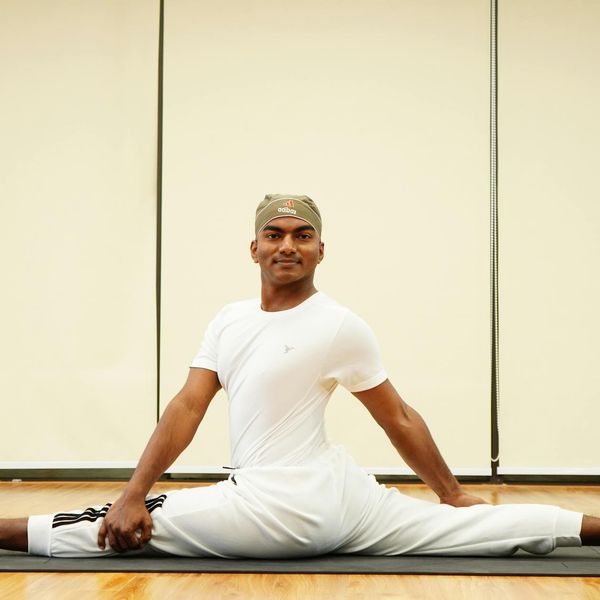 Focused male athlete stretching on a yoga mat.